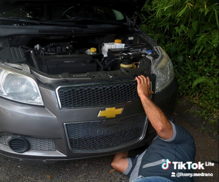 Harry revisando parte frontal de un Chevrolet